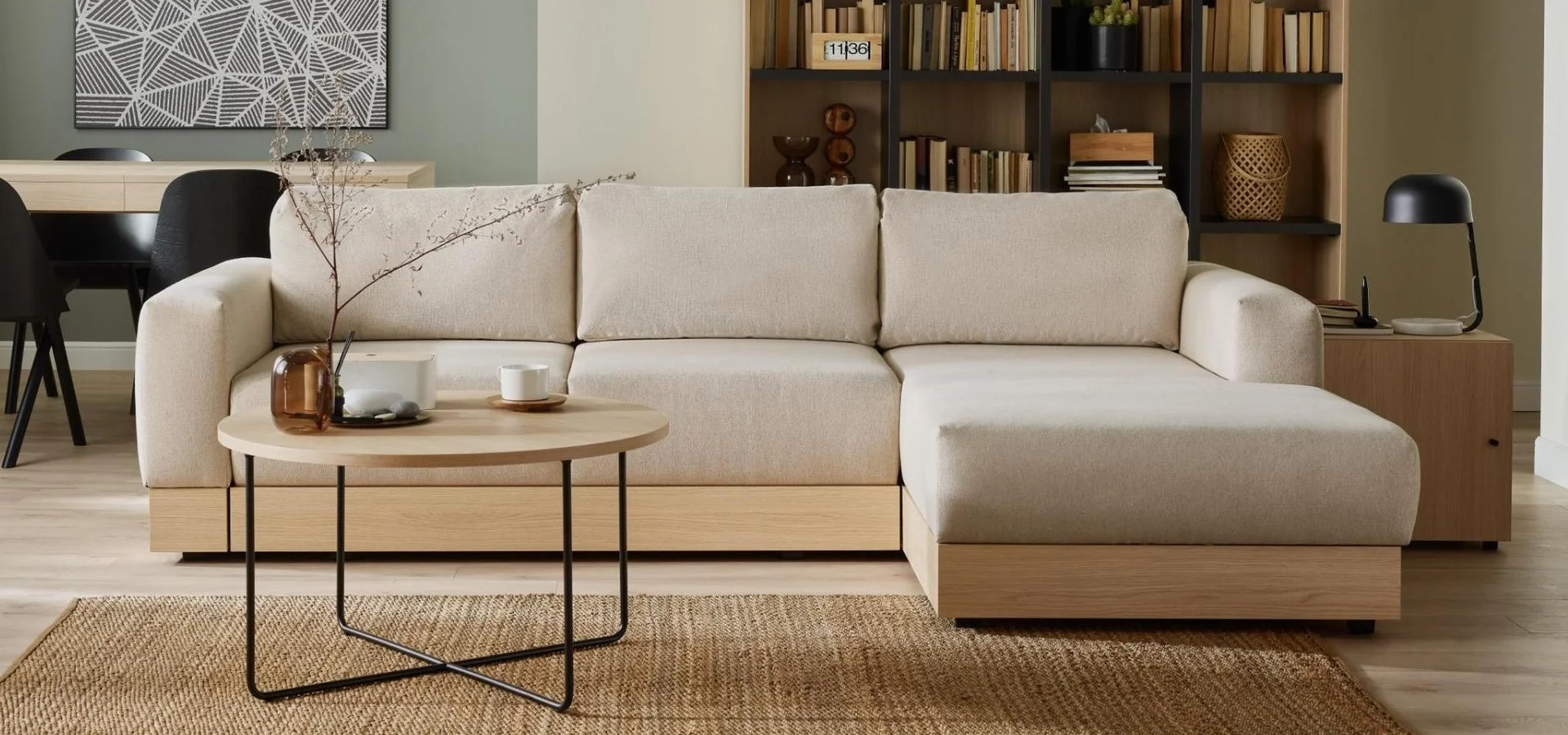 Jasna narożna sofa z drewnianą listwą w przytulnym salonie